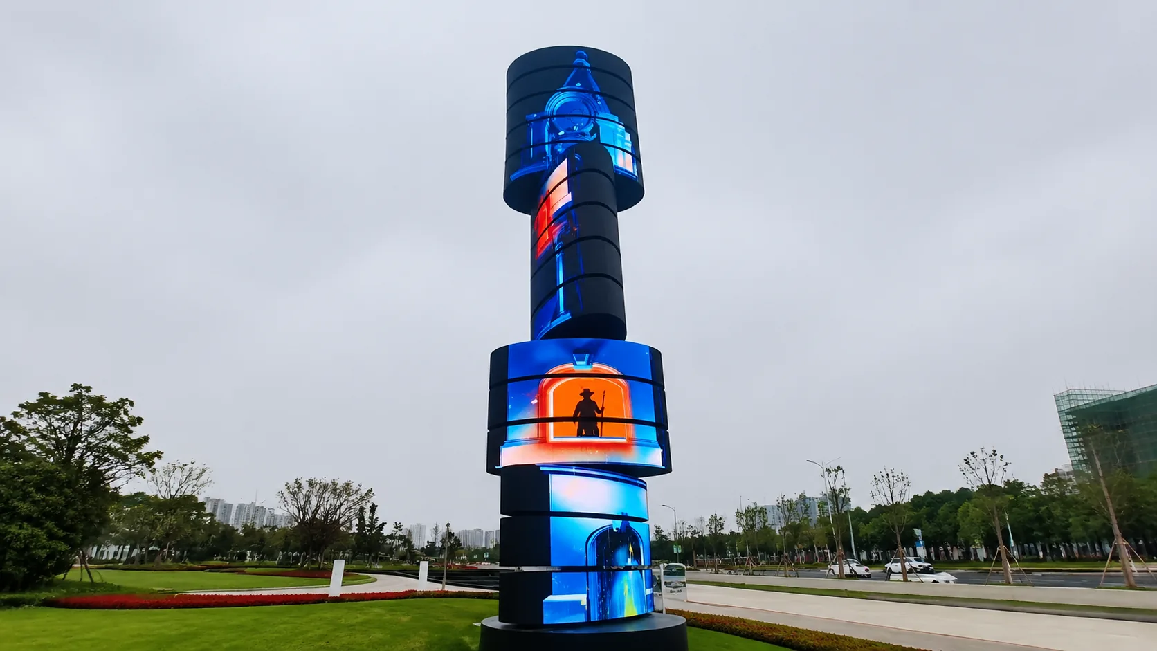 Outdoor Rotating Landmark Display Rotating LED tower in an outdoor public plaza at dusk